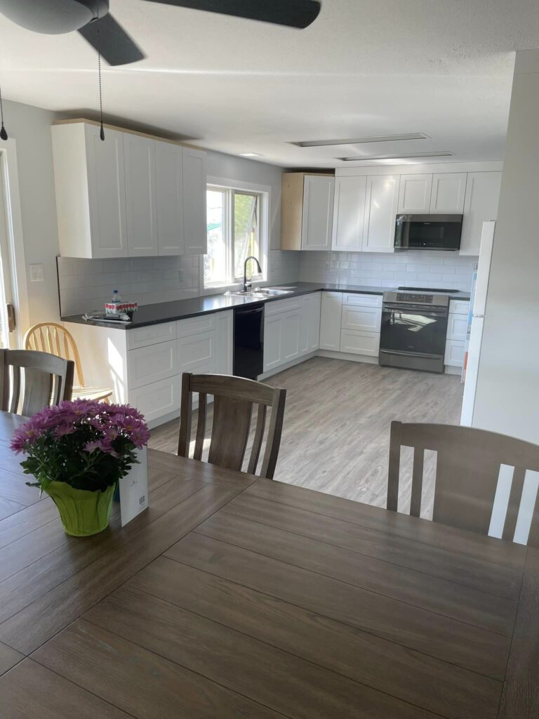 View of the new revitalized kitchen with beautiful cabinets and countertops, new flooring, fresh paint and open floorplan design. Rip and Fix construction gave this kitchen a new modern look.